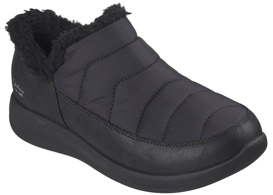 A black, slip-on winter ankle boot featuring a quilted, padded upper, a plush faux-fur collar, and a thick, solid-colored rubber sole.