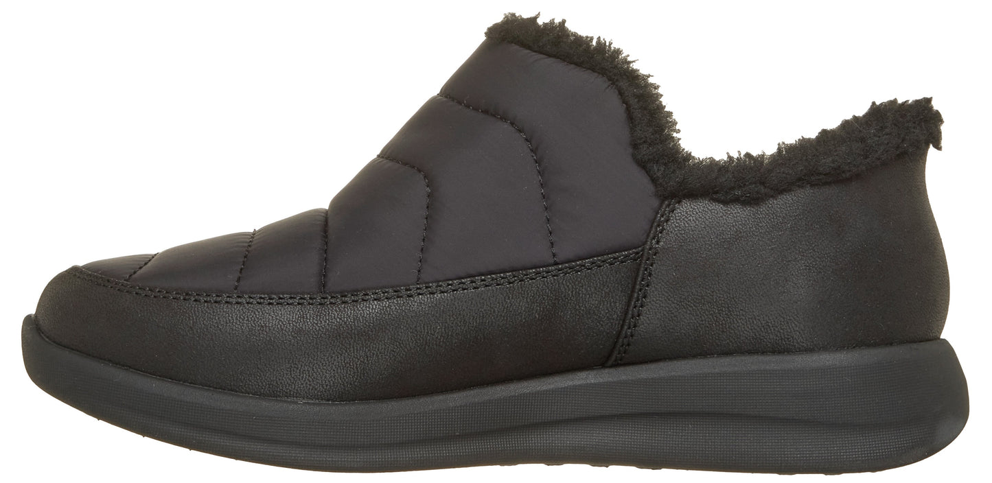 A black slip-on shoe with a quilted upper, faux fur lining at the ankle, and a thick, matching black rubber sole.