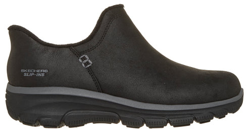 A black slip-on shoe with a textured, leather-like upper, featuring a thick black and grey cushioned sole, a Skechers Slip-ins logo on the side, and a simple design without laces.