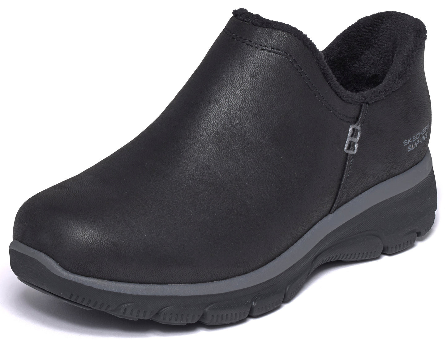 A black, slip-on ankle boot with a rounded toe, a grey midsole, a black lugged outsole, and a soft, dark-colored faux fur lining along the collar, with the text 'SKECHERS SLIP-INS' visible near the heel.