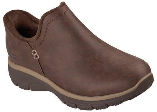 A brown, slip-on comfort shoe with a soft, fuzzy-lined collar, a rounded toe, and a thick, layered, dark brown and tan rubber outsole.