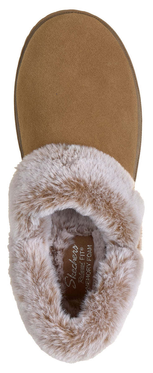 A tan suede slipper viewed from directly above, featuring a soft, grey faux fur lining and a branded footbed with the text Relaxed Fit Memory Foam.