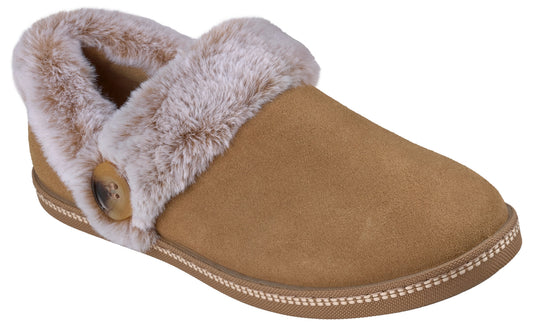 A tan suede slipper with a soft, plush white faux-fur cuff and a small decorative brown button on the side.