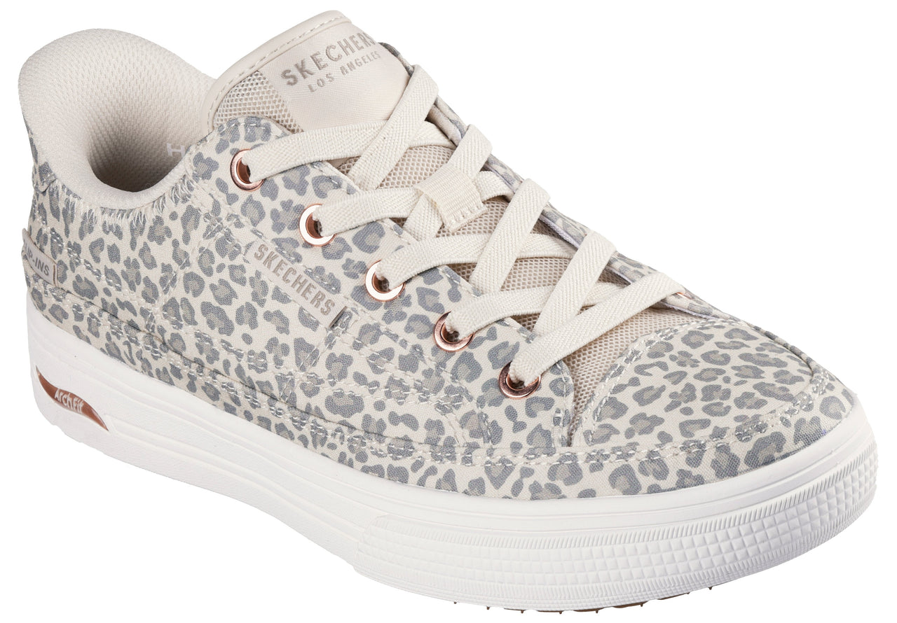 Leopard print sneaker with white laces, rubber soles, and visible "SKECHERS LOS ANGELES" text.