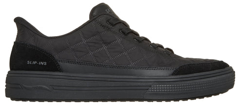 A black Skechers Slip-ins sneaker viewed from the side, featuring a quilted upper, suede-like heel and toe panels with the text 'SLIP-INS' on the heel, and a thick, textured black rubber sole.