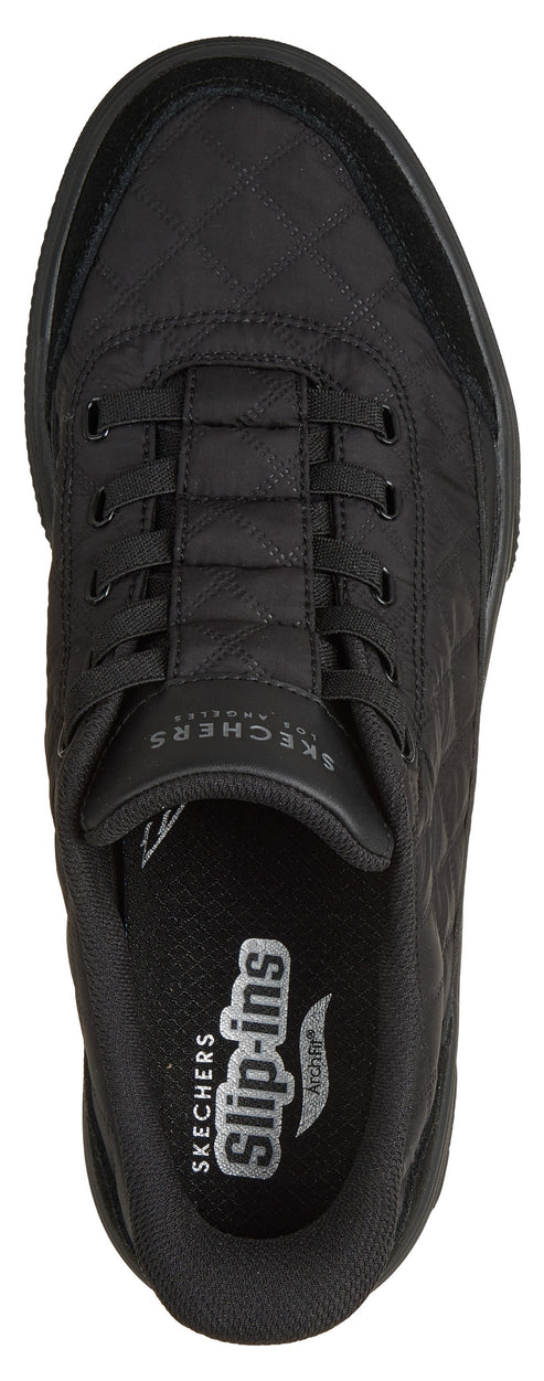 A top-down view of a black slip-on athletic shoe with a quilted upper texture, featuring the text "SKECHERS" on the tongue and "SKECHERS slip-ins" with an "ARCH FIT" logo printed on the insole.