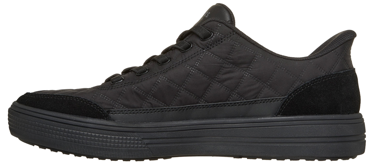 A black sneaker with a quilted fabric upper, a thick ribbed midsole, suede-like overlays at the toe and heel, and matching black laces.
