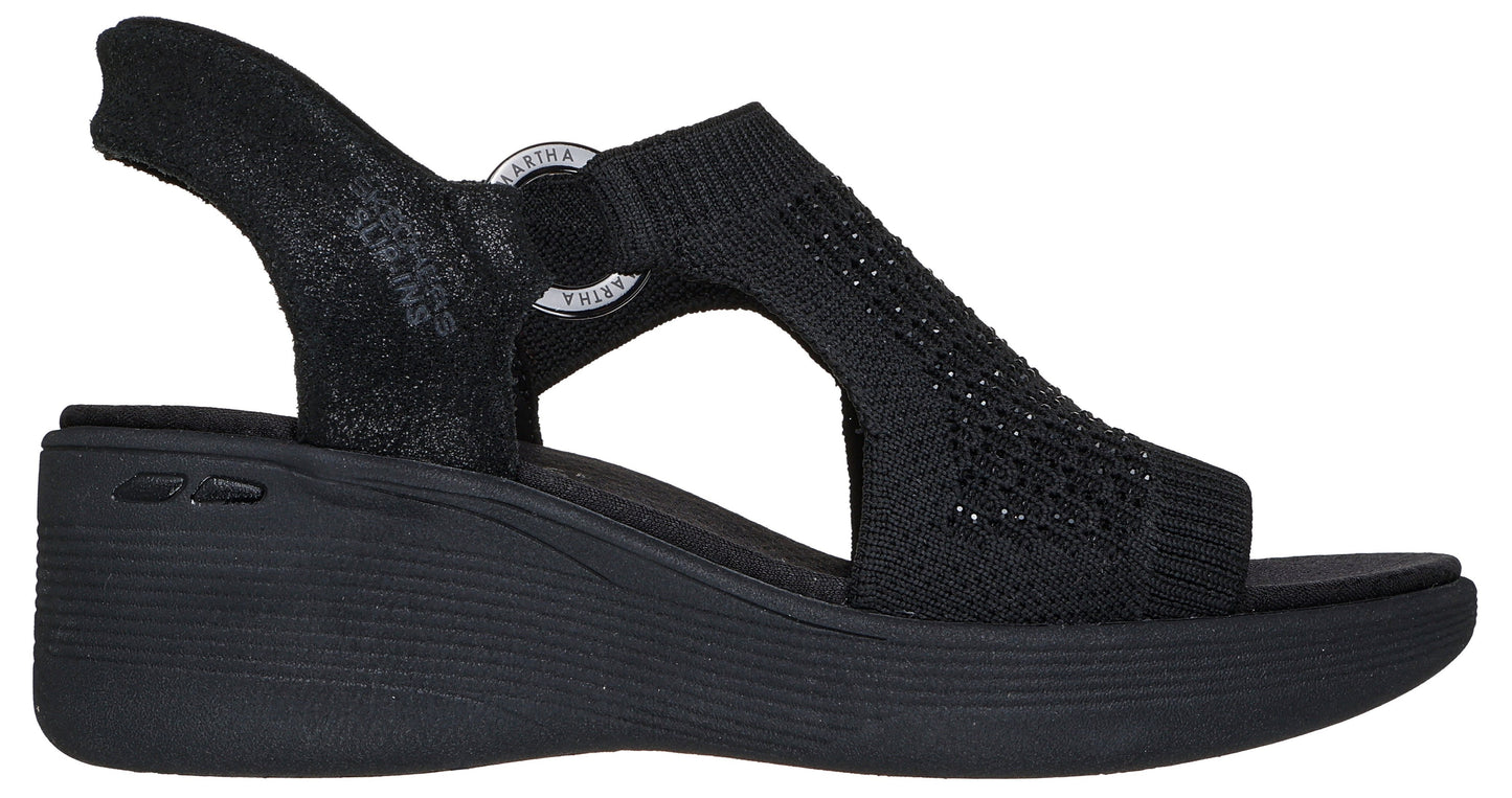 Black sandal with a wedge heel and knit upper, plus a heel strap and circular logo at the ankle.