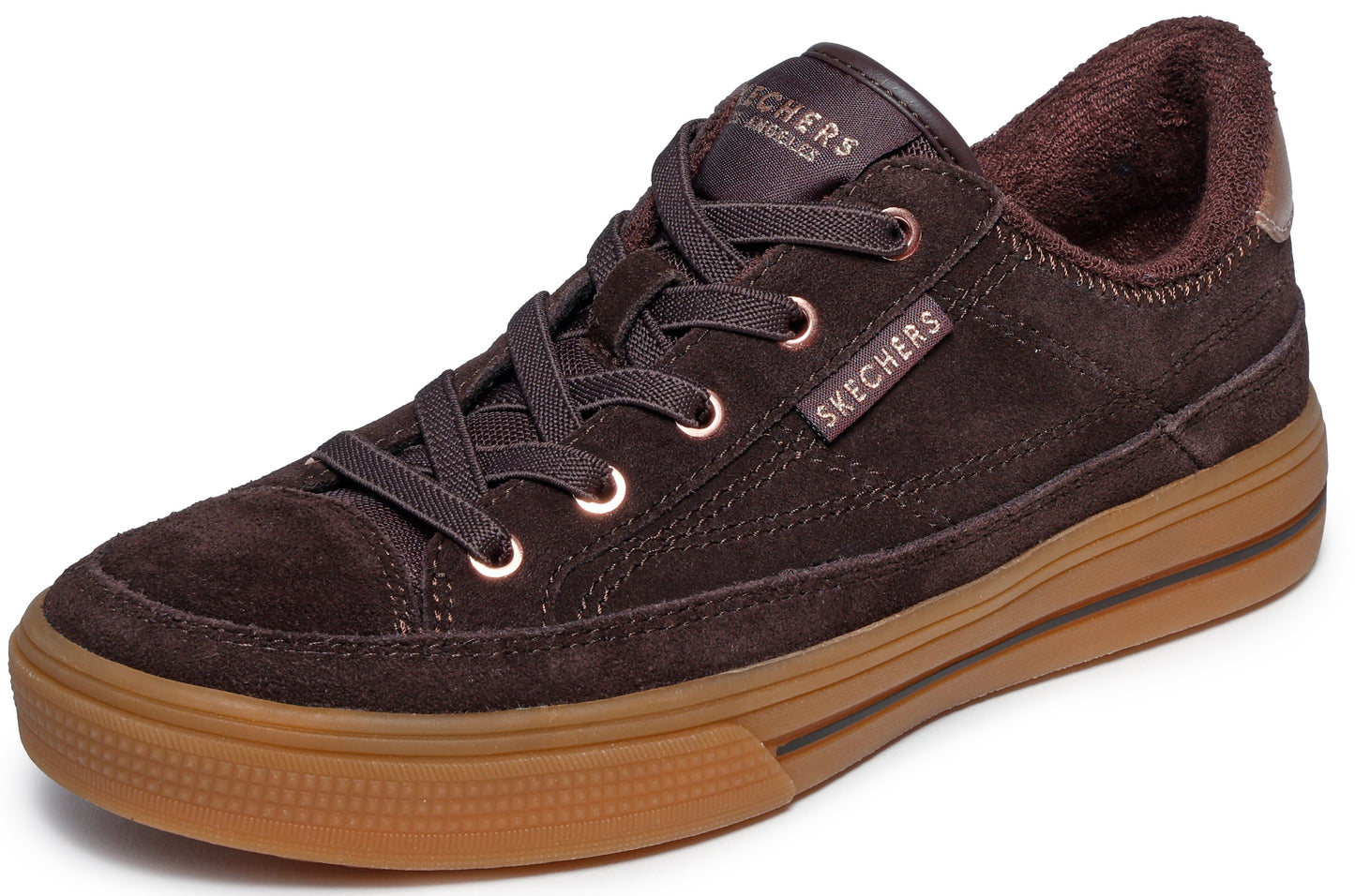 A brown suede sneaker featuring a low-top lace-up design with metallic eyelets, a fuzzy brown collar lining, and a tan rubber platform sole with a textured bumper, displaying 'SKECHERS' branding on the tongue and side.