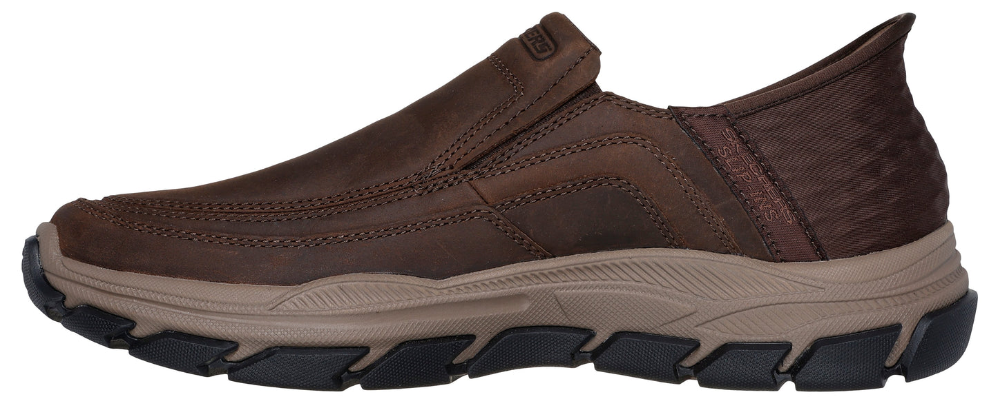 A brown slip-on casual shoe with a textured, rugged dark brown upper, a tan midsole, and a black lugged rubber outsole.