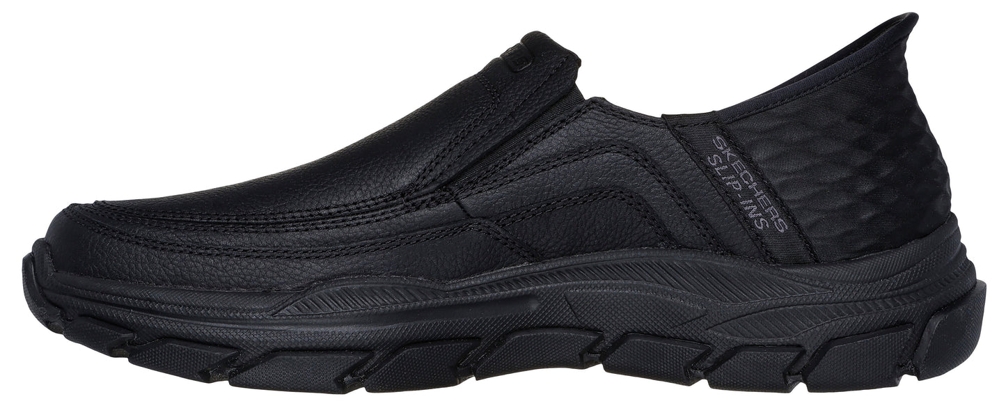 A black slip-on shoe with a thick, heavily textured sole, and the text "SKECHERS SLIP-INS" visible on the heel.