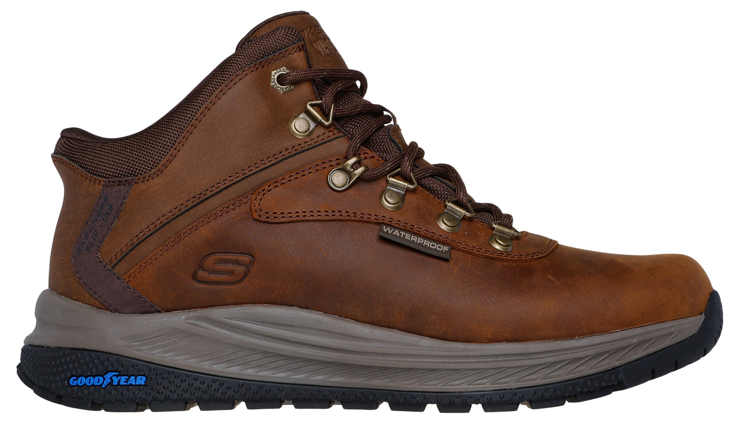 A brown leather ankle-high boot with metal eyelets, a waterproof label, a visible S logo, a gray midsole and a Goodyear outsole.