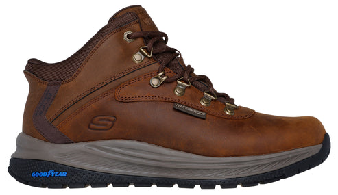 A brown leather ankle-high boot with metal eyelets, a waterproof label, a visible S logo, a gray midsole and a Goodyear outsole.