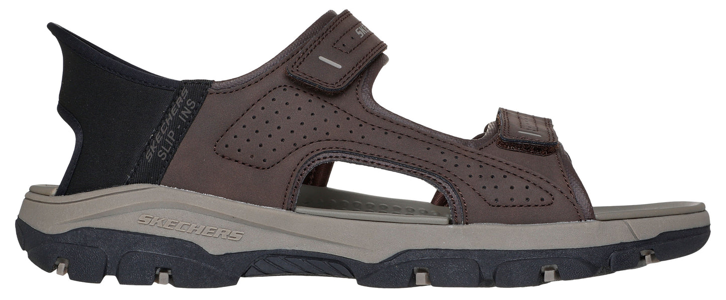 A brown sandal with a black heel.