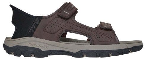 A brown sandal with a black heel.