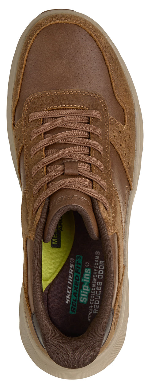 A top-down view of a brown suede and smooth leather sneaker with laces, showing the interior with a bright yellow insole and printed text that reads Skechers Relaxed Fit Slip-ins Air-Cooled Memory Foam Reduces Odor.