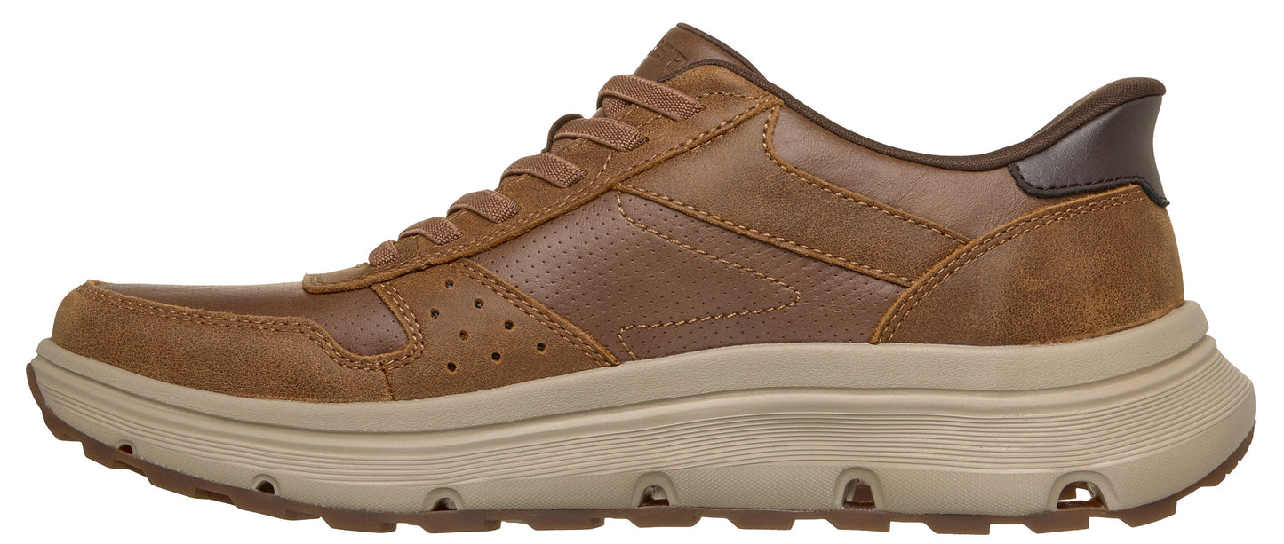 A brown leather sneaker featuring a lace-up design, perforated side panel details, and a thick, ridged tan rubber outsole.