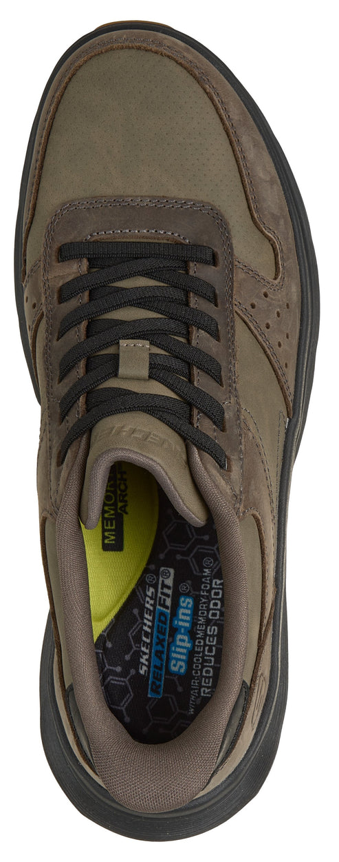 A top-down view of a brown Skechers Slip-ins sneaker with black laces and a memory foam insole featuring visible branding and text.