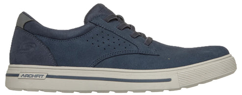A low-top, lace-up sneaker in navy blue suede with a perforated side panel and a white, ribbed-texture sole featuring an Arch Fit logo label on the heel.