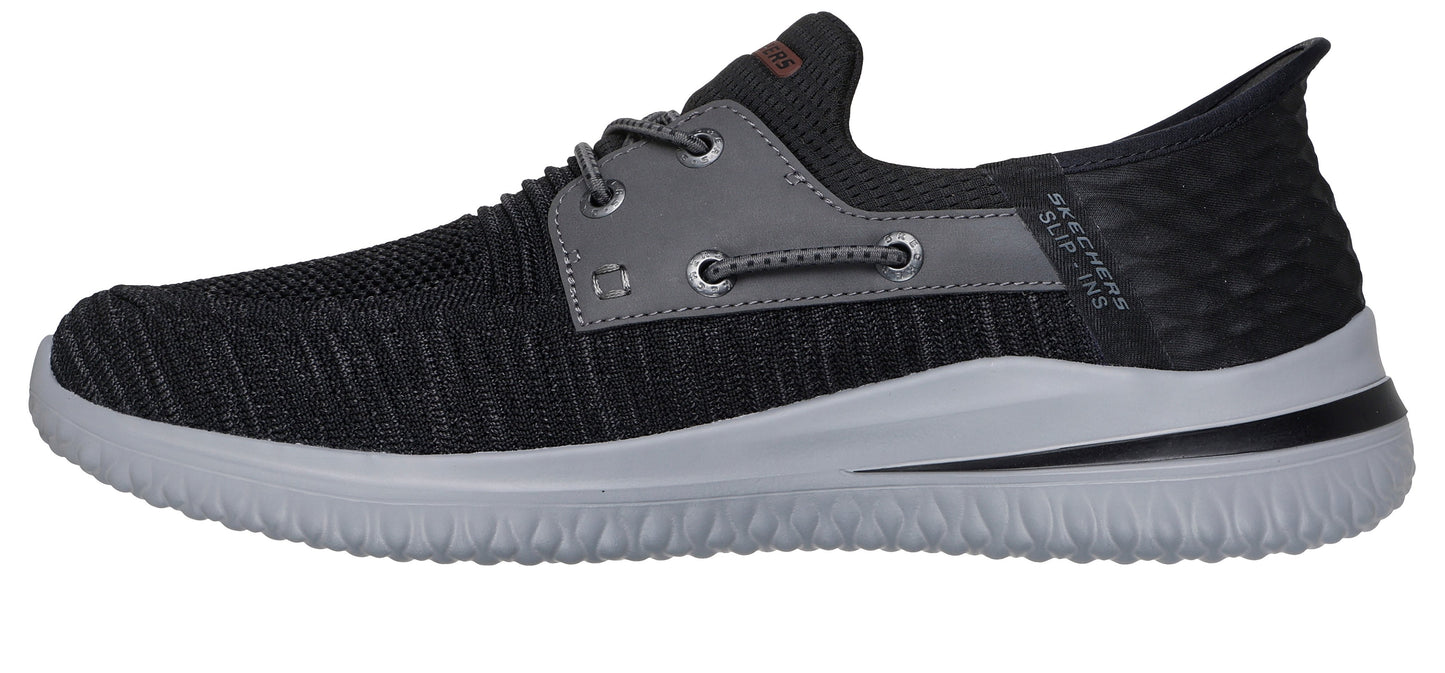 A gray and black slip on shoe with a light gray sole.