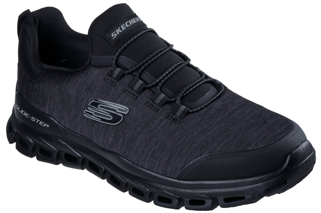 A black Skechers Glide-Step athletic sneaker with a textured mesh upper, slip-on style elastic laces, a cushioned black sole with distinctive geometric cutouts, and a prominent grey S logo on the side.