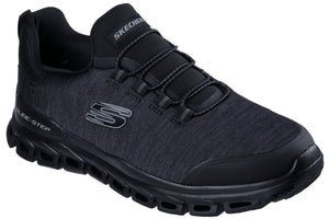 A black Skechers Glide-Step athletic sneaker with a textured mesh upper, slip-on style elastic laces, a cushioned black sole with distinctive geometric cutouts, and a prominent grey S logo on the side.