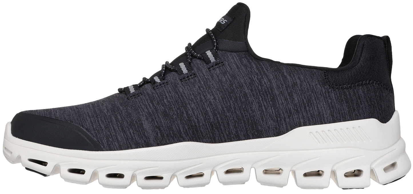 A black, heathered-fabric sneaker with a white, thick, sculpted sole featuring multiple cut-out gaps along the sides.