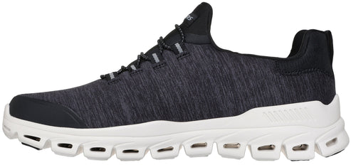 A black, heathered-fabric sneaker with a white, thick, sculpted sole featuring multiple cut-out gaps along the sides.