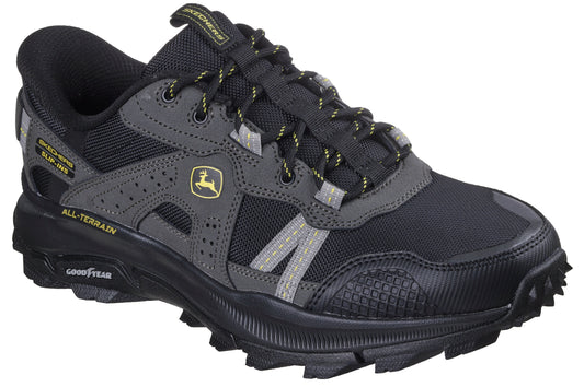 A black and gray athletic shoe with Goodyear sole and All-Terrain text; green and yellow John Deere logo visible on side.