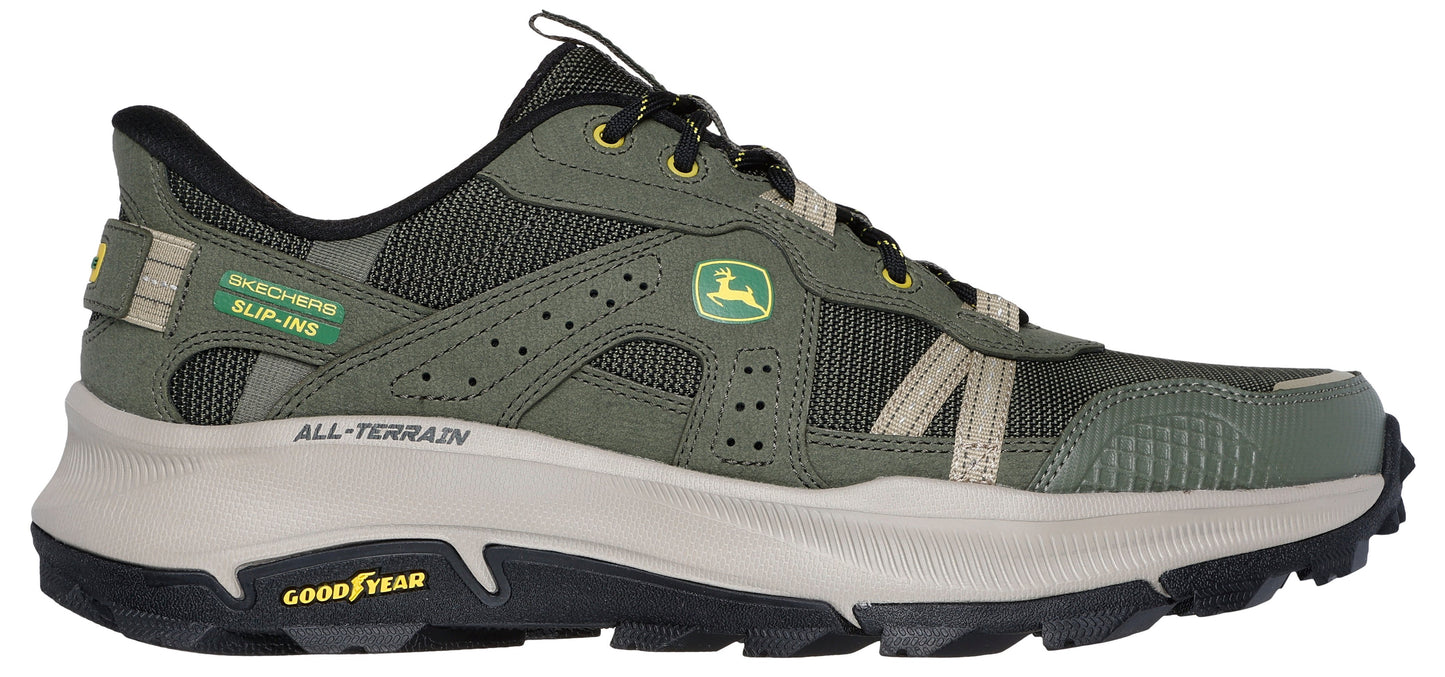 A green trail-running shoe with a white midsole and black outsole, featuring the John Deere logo.