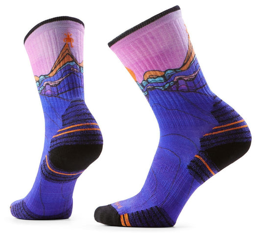 Two purple wool socks featuring a scenic mountain landscape with an orange sun.