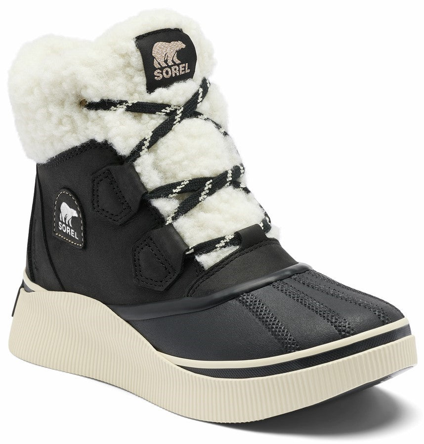 A black SOREL winter boot with a thick cream-colored textured rubber sole, a white faux-fur cuff, and black crisscross laces.