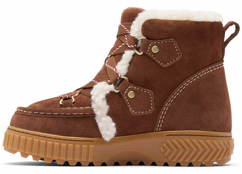 A brown suede ankle boot with white faux-fur trim along the collar and laces, featuring gold-toned metal eyelets, a thick serrated gum rubber sole, and a pull loop at the heel.