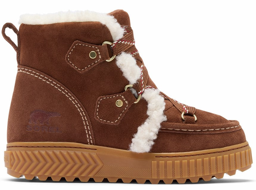 A brown suede ankle boot with white shearling trim along the collar and front lacing, featuring gold-tone hardware and a thick, textured tan rubber lug sole.