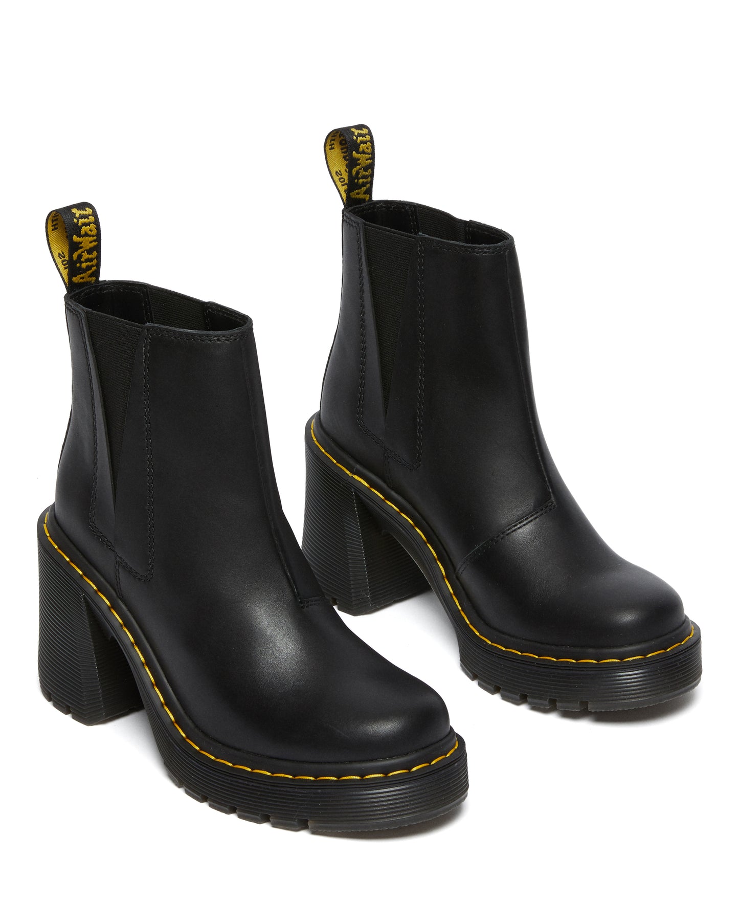 Pair of black leather heeled Chelsea platform boots with yellow "AirWair" heel tabs.