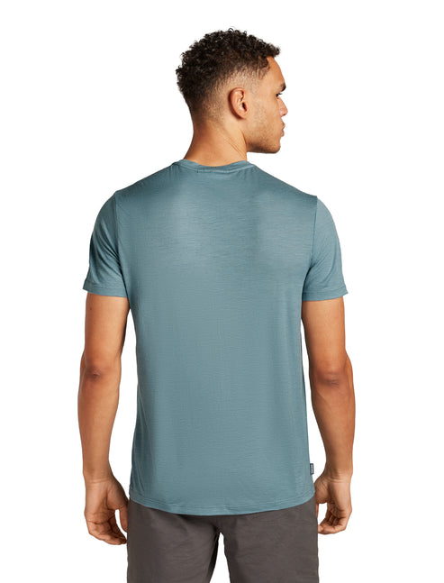 Person wearing a solid teal crewneck t-shirt, seen from the back.