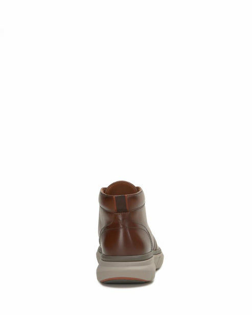 Rear view of a brown leather ankle boot with a thick, light gray sole.