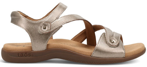 A gold sandal with an adjustable strap.