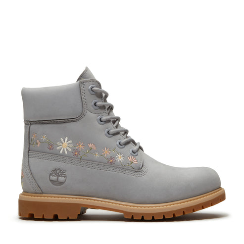 Gray ankle boot with a tan sole and flower embroidery.