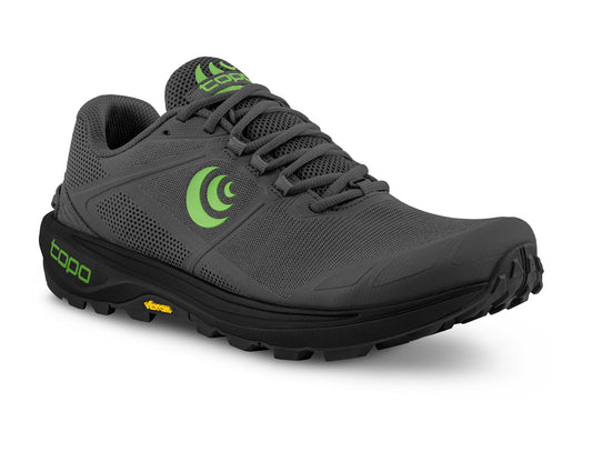 Gray athletic shoe with black sole, has green logo and shoe laces