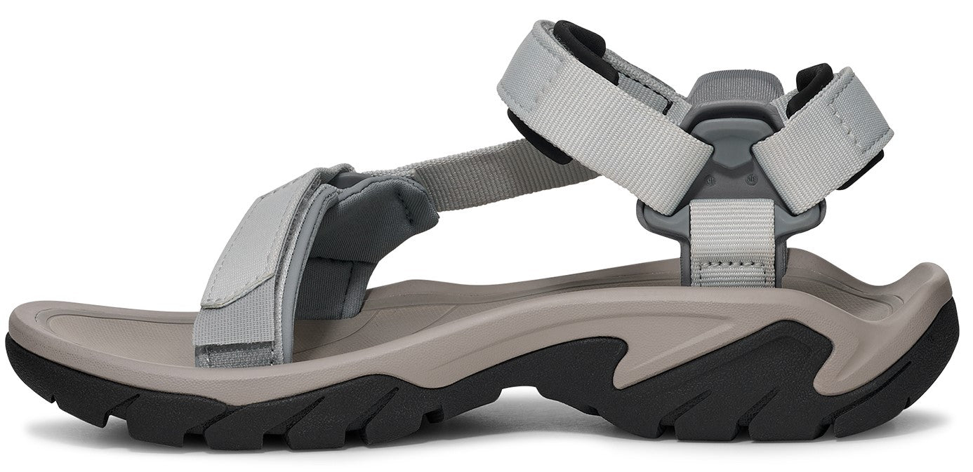 Side view of a sandal with grey fabric straps and a thick grey and black sole.