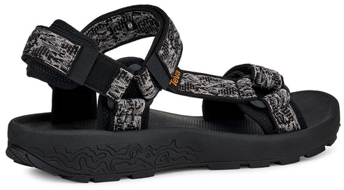 Black platform sandal with patterned black and gray straps and the word Teva on one strap.