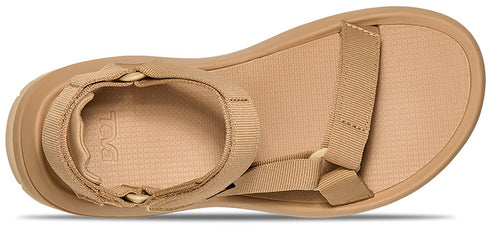 A beige sandal with a flat sole and multiple straps.
