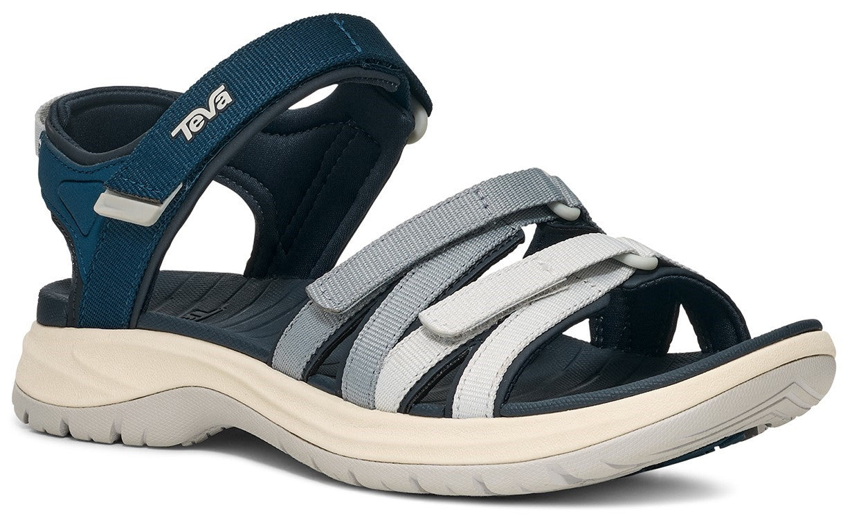 A navy blue sandal with a white sole and gray and white straps.
