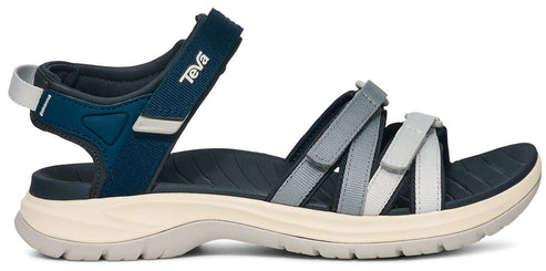 A sandal with gray and white velcro straps over the foot and ankle. The heel and ankle strap is blue with a brand logo on the side.