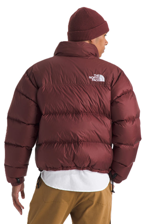 Maroon puffer jacket with a knit hat, showing the white logo on the upper back.
