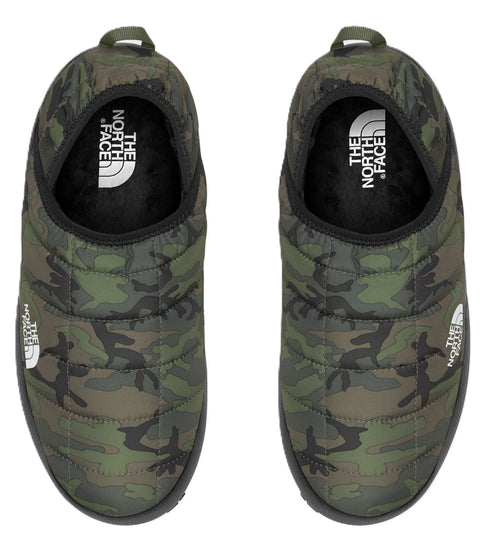 Overhead shot of two camouflage print slipper mules, the white logo is visible on the side of one slipper and the insole of both.