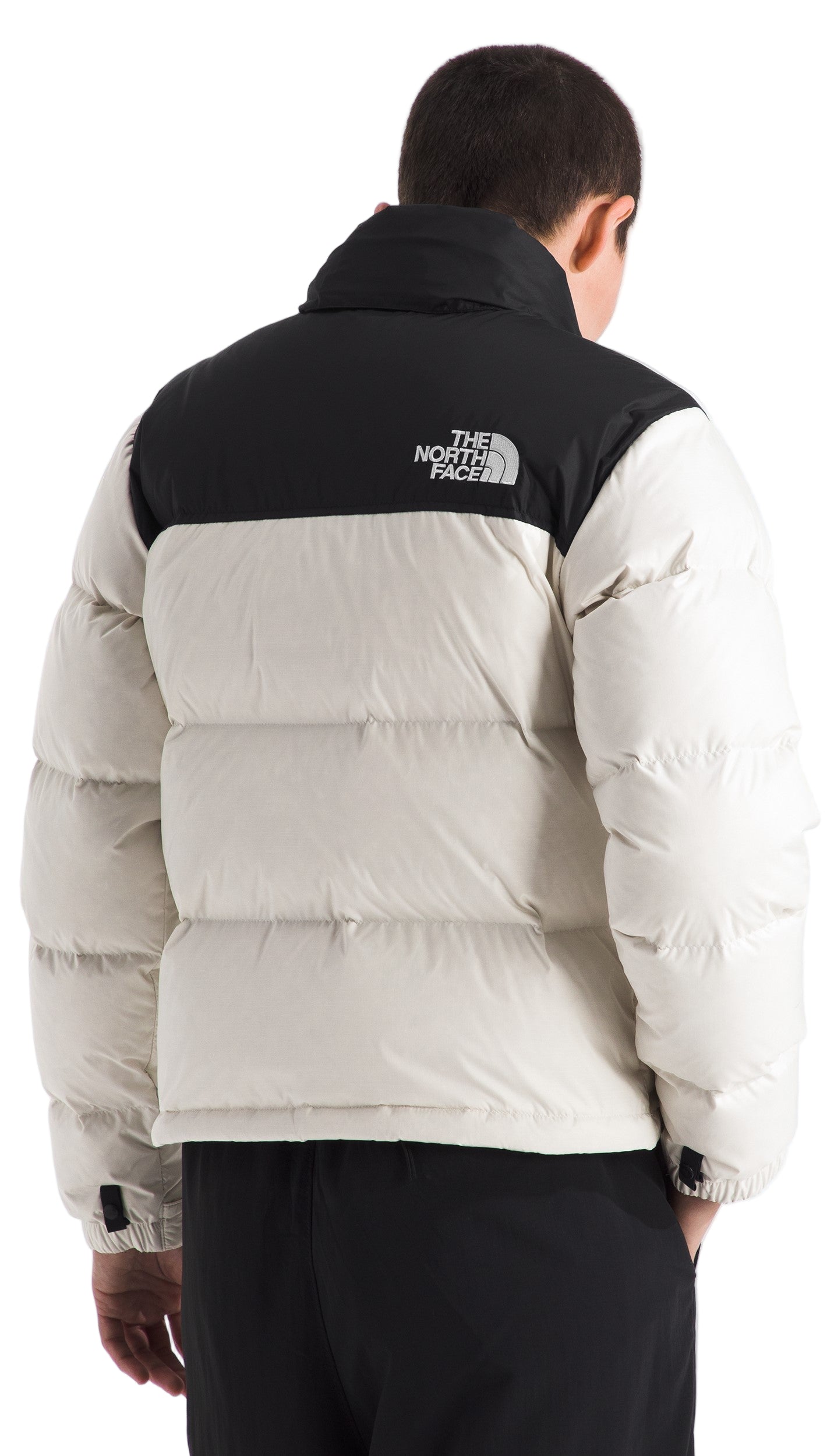 Back view of a puffy coat with a black yoke and an off-white body.