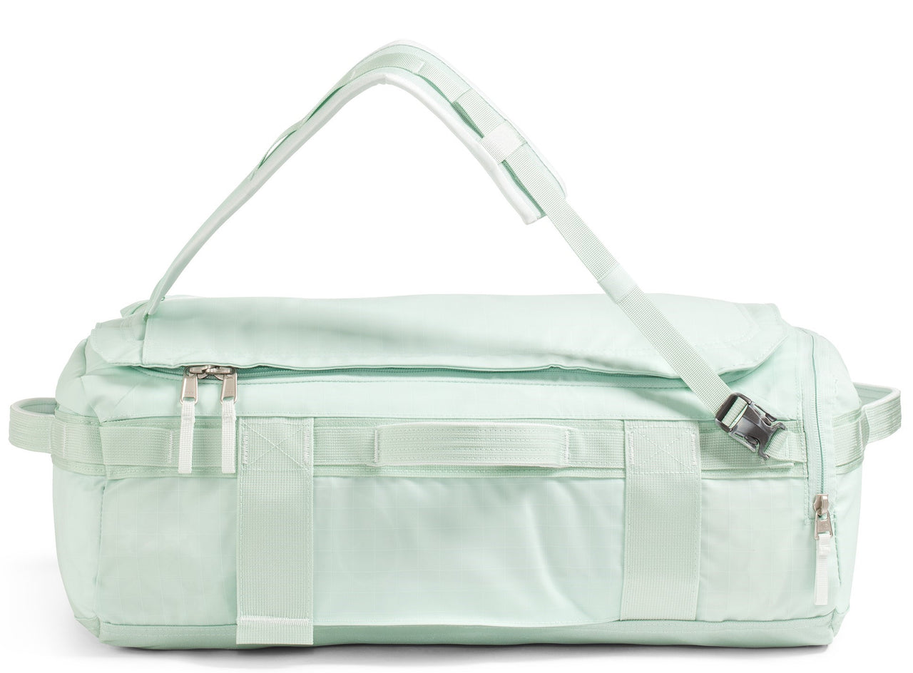 Mint-green duffel bag with top straps and zippers.