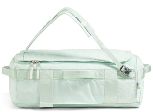 Mint-green duffel bag with top straps and zippers.